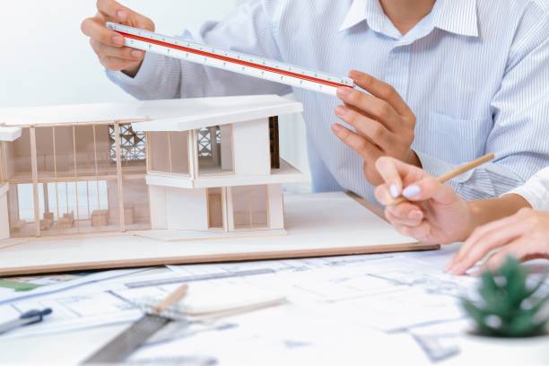 istock Closeup of engineer team working together to measure house model. Immaculate. 1766797192