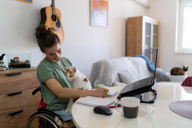 istock Happy disabled freelancer enjoying with her cat at home office. 1766812499