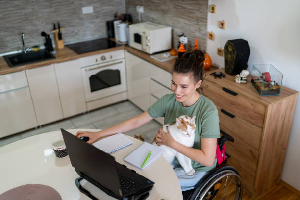 istock Above view of happy disabled student e-learning over laptop at home. 1766812502