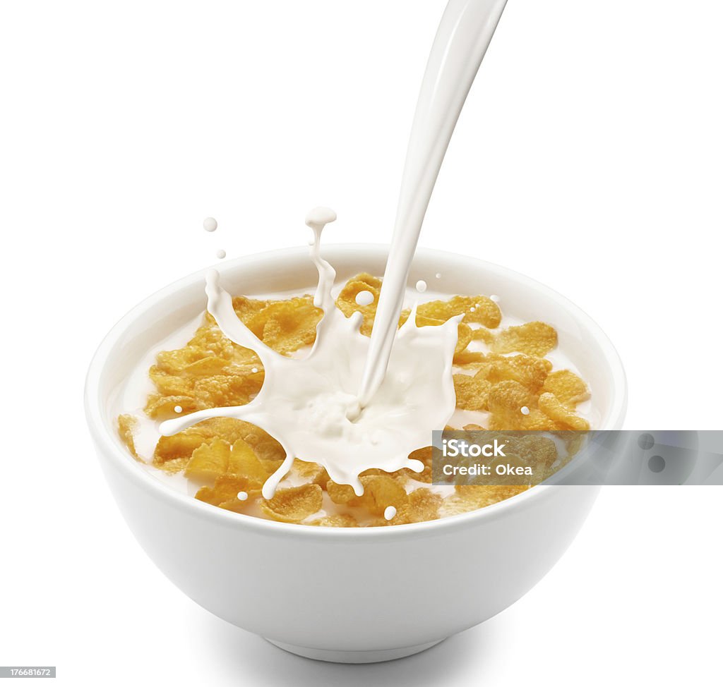 Milk splashing from a height into a bowl of cornflakes pouring milk into corn flakes creating splash Milk Stock Photo