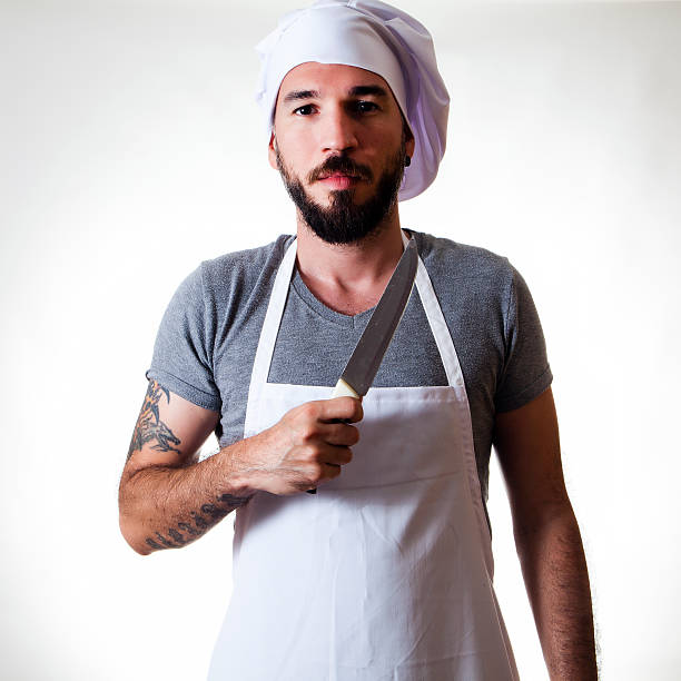 Man Chef in uniform holding a kitchen knife