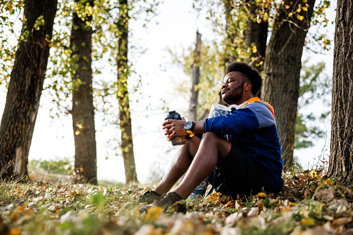Sportsman doing breathing exercise outdoor during autumn sunset
