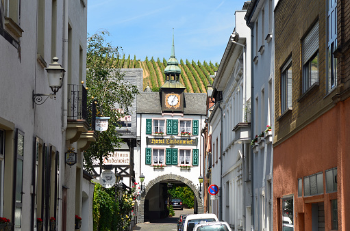 Ruedesheim, Germany - May 29, 2011: Narrow street with buildings, hotel and clock tower in the UNESCO world heritage site of Rhine Valley
