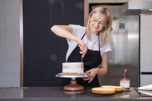 istock Satisfied confectioner smiling while smearing cake layers with fresh organic cream 1766851011