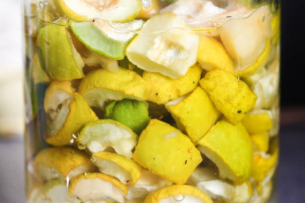Quince in glass jar. Sugar covered fruits releases juice. Marinating fruits background. Quince tincture production. Homemade fruit alcohol. cydonia stock pictures, royalty-free photos & images