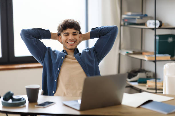 istock Happy Young Man Looking At Laptop Relaxing At Workplace Indoors 1766860284