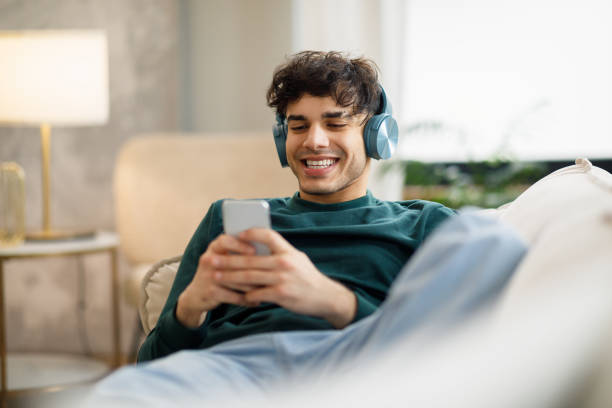istock Middle Eastern Guy Websurfing On Smartphone Wearing Wireless Headphones Indoor 1766860752