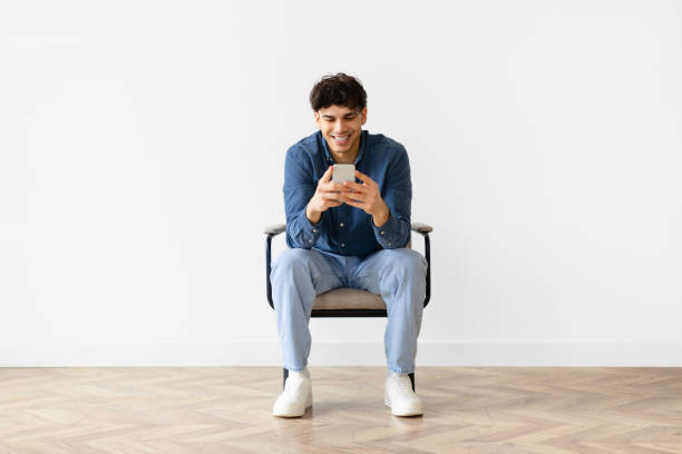 istock Middle eastern young man texting on smartphone over white wall 1766861316