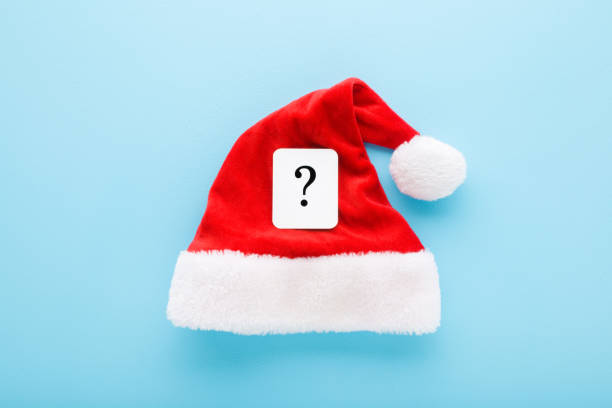 istock White card of black question mark on bright red Santa Claus hat on light blue table background. Pastel color. Closeup. Christmas issues concept. Top down view. 1766861400