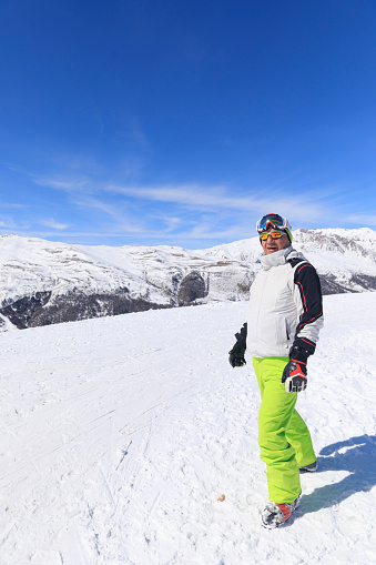 Active lifestyle, Portrait Vital senior  men snow skier, enjoying on sunny ski resorts.  Snowcapped mountain  Alps  ski area. Ski resort Livigno. italy, Europe.