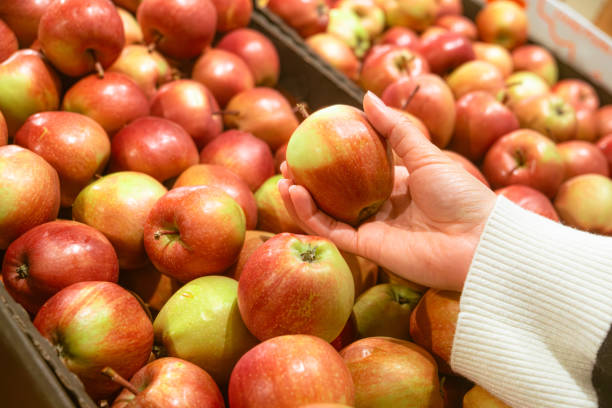 istock hand taking apple from grocery store shelf 1766882255