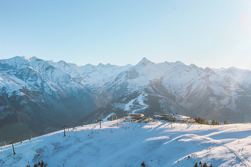 Ski resort Zell-am-See in Austria. Panoramic views of the snow-covered slopes and ski lifts. Winter sports, sunny mountain landscape in the Alps. Horizontal photo for sport or travel content.