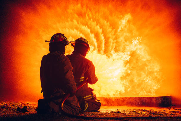 istock Fearless Firefighters Battling Blaze with Water and Extinguishers. Firefighters in Action, Extinguishing Fire with Teamwork and Courage. Intense Firefighting Training Exercise. 1766887329