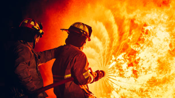 istock Fearless Firefighters Battling Blaze with Water and Extinguishers. Firefighters in Action, Extinguishing Fire with Teamwork and Courage. Intense Firefighting Training Exercise. 1766891878