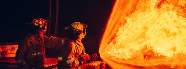 istock Fearless Firefighters Battling Blaze with Water and Extinguishers. Firefighters in Action, Extinguishing Fire with Teamwork and Courage. Intense Firefighting Training Exercise. 1766893484