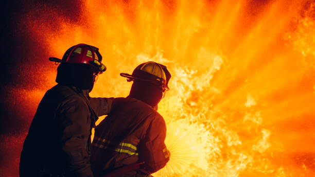 istock Fearless Firefighters Battling Blaze with Water and Extinguishers. Firefighters in Action, Extinguishing Fire with Teamwork and Courage. Intense Firefighting Training Exercise. 1766893494