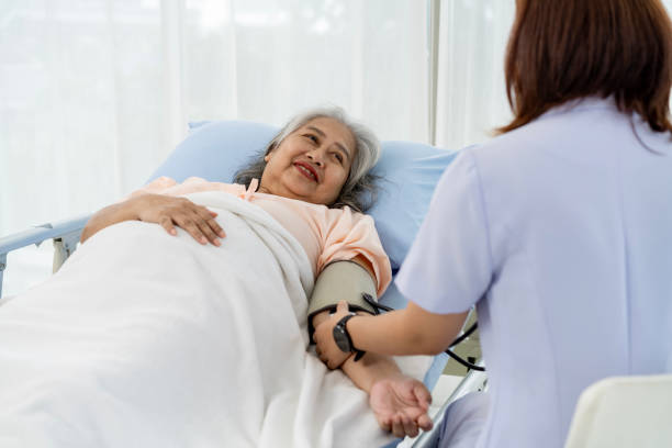 tägliche inspektion eine krankenschwester oder pflegekraft eines älteren patienten misst den blutdruck und die herzfrequenz des patienten. - hypertensive blood pressure gauge mercury physical pressure stock-fotos und bilder