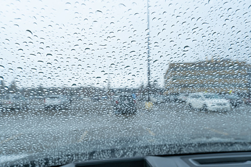 raindrops on a car windscreen in a parking lot