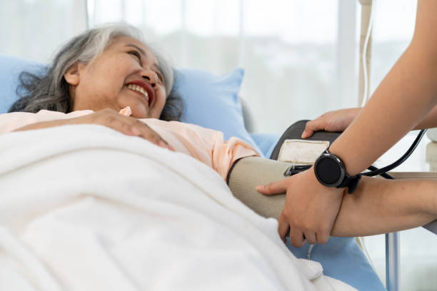 eine krankenschwester oder pflegekraft eines älteren patienten bereitet sich darauf vor, den blutdruck und die herzfrequenz des patienten zu messen. - hypertensive blood pressure gauge mercury physical pressure stock-fotos und bilder