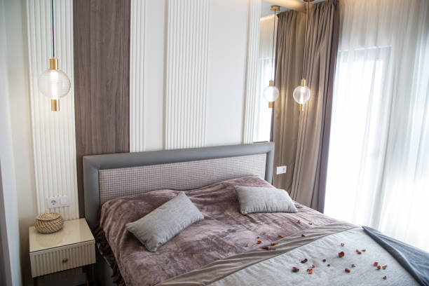 istock Interior of a hotel bedroom with double bed, pillows and bedside table 1766926697