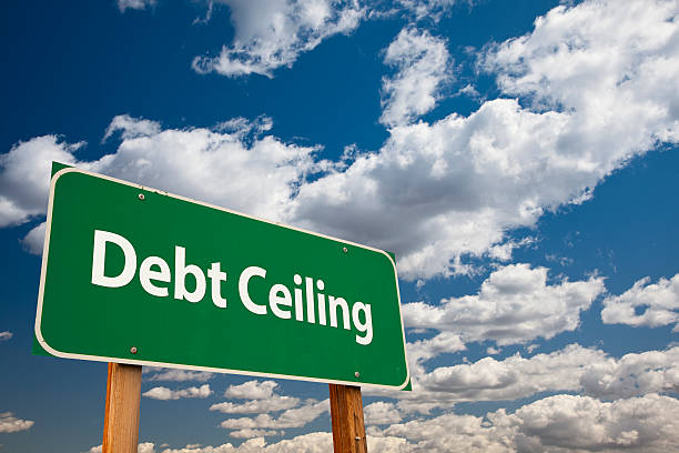 Debt Ceiling Green Road Sign Debt Ceiling Green Road Sign Over Clouds and Sky. debt ceiling stock pictures, royalty-free photos & images