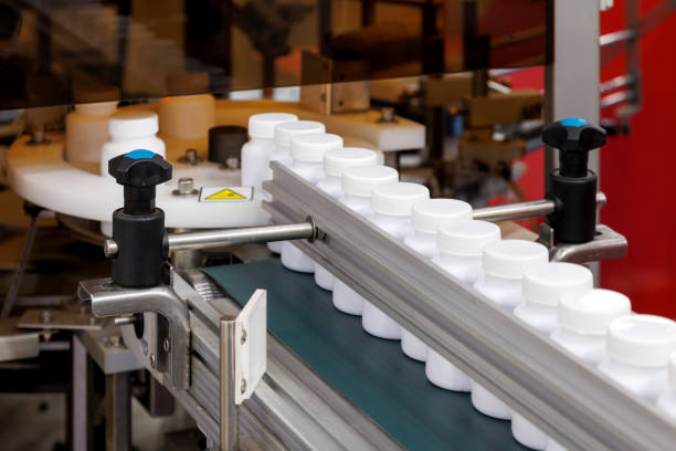 istock white plastic bottle moving on conveyor belt of auto capping and labeling machine at cosmetic, supplement or medicine pharmaceutical manufacturing. 1766937449