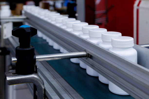 istock white plastic bottle moving on conveyor belt of auto capping and labeling machine at cosmetic, supplement or medicine pharmaceutical manufacturing. 1766937478