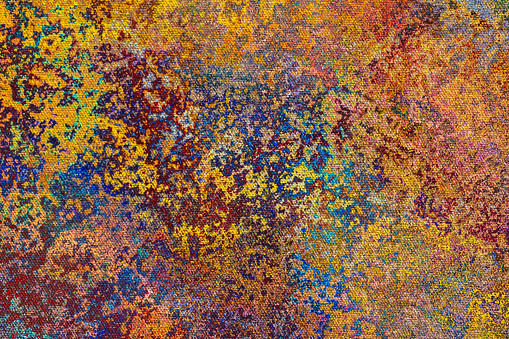 Abstract colorful background with chaotic spots of paint over canvas texture