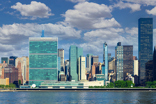 High Resolution Stitched Image of New York Skyline with UN Building (Headquarters of the United Nations), Manhattan Upper East Side Residential and Office High-rises, FDR drive, Green Trees, Morning Blue Sky with Clouds and water of East River. Canon EOS 6D (Full Frame censor) DSLR and Canon EF 85mm f/1.8 Prime lens. 3:2 Image Aspect Ratio. This image is downsized to 50MP.