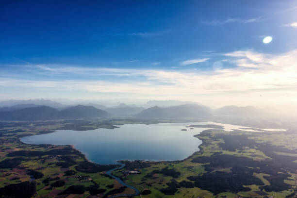 view over Lake Chiemsee to the Alps with clouds, dust and blue sky