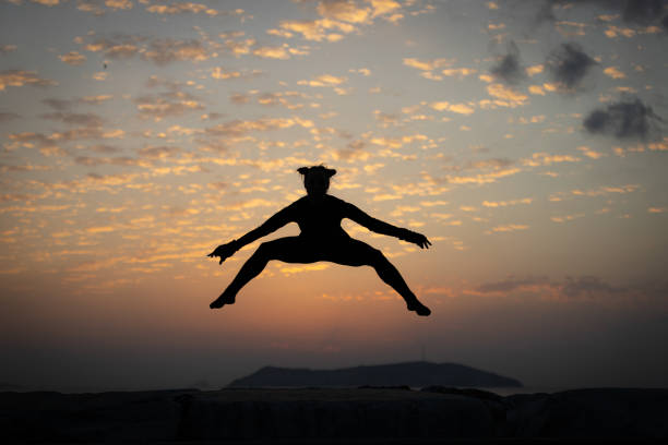 istock Flexible young woman is jumping at sunset. 1766989561