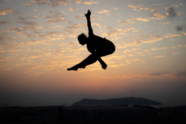 istock Flexible young woman is jumping at sunset. 1766989564