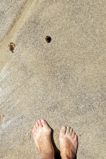 Yound woman feet on Playa de los Ojos - Los Ojos Beach - at El Puerto de la Cruz, Peninsula Jandia, Fuerteventura, Canary Islands, Spain - 21.09.2023