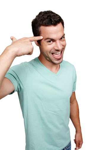 A handsome young man pointing at his head while isolated on a white background