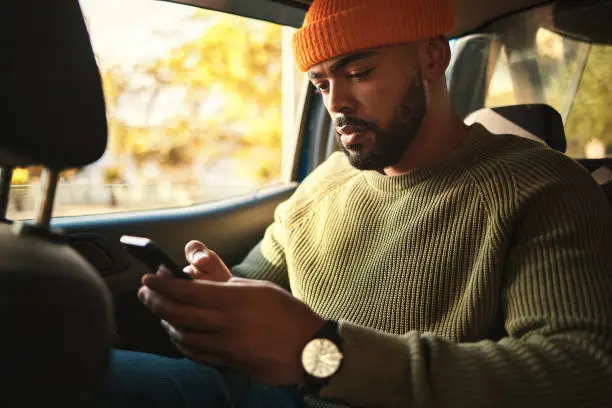 Photo of Man, using phone in car and social media, travel and transportation, navigation app and communication. Email, chat and taxi cab, technology and text message with transport and search location online