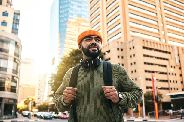 istock City, thinking and man with ideas, travel and vision with solution, planning and gen z with headphones. Person, hipster and guy with headset, outdoor or urban buildings with fashion or stylish outfit 1767008422