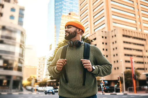 Man in city, backpack and smile on morning commute to university campus for education with buildings. Opportunity, study and happy gen z college student, walking on urban street and travel to school.