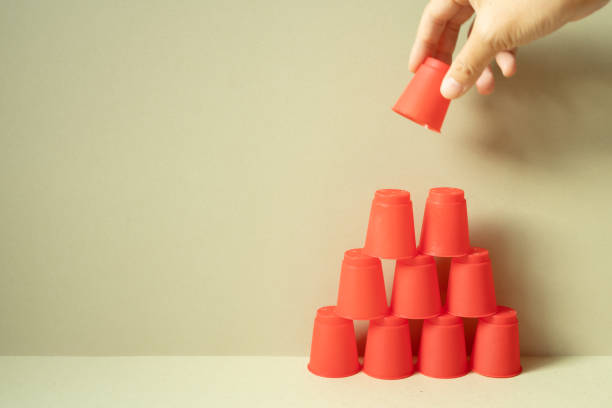 istock Pyramid of red plastic cups on desk. khaki beige background. teamwork balance business develop achievement growth concept 1767024701