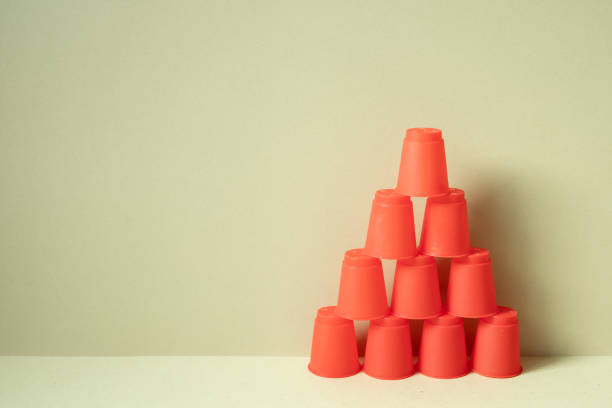 istock Pyramid of red plastic cups on desk. khaki beige background. teamwork balance business develop achievement growth concept 1767024837