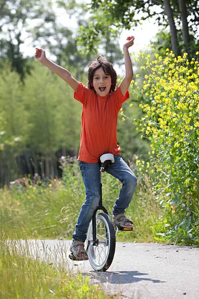 Boy balancing on a unicycle in the park