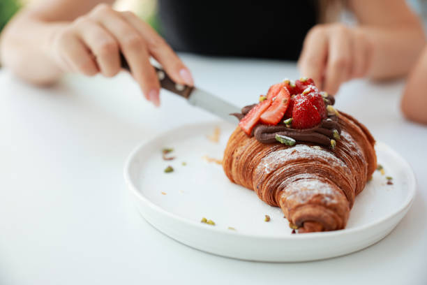 Cup of filter coffeee and croissant on table