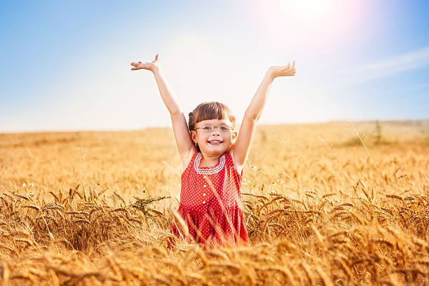 Little girl with arms outstretched in a wheat field