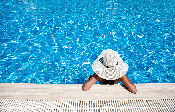 istock Woman with hat relaxing by the pool 176706653