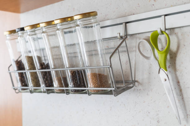istock Glass spice jars with spices on a hanging metal shelf. 1767070609
