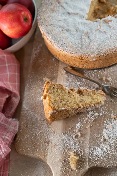 Homemade fluffy almond cake baked without flour. Served sliced on rustic and wooden table background.