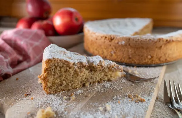 Very tasty and fluffy almond cake. Baked without flour. Served whole and sliced on rustic and wooden table background. closeup