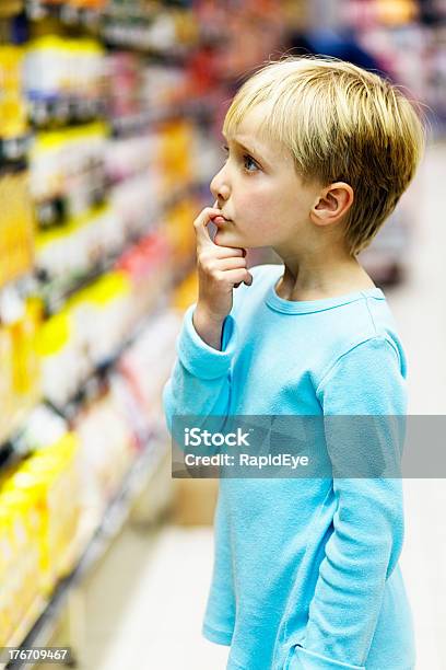 Dziewczynka W Supermarkecie Próbuje Decyzję W Sprawie Zakupu - zdjęcia stockowe i więcej obrazów Wybierać
