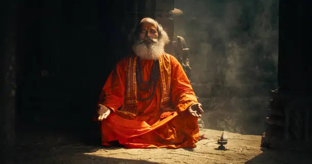 Authentic Shot of An Indian Senior Monk Practicing Yoga In A Temple Setting. Serene And Meditative Display Of Ancient Spiritual Practice, Seeking Profound Sense of Inner Peace and Enlightenment