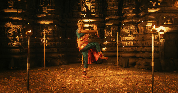 Mesmerizing Slow-Motion Portrait of Female Indian Dancer Expressing Herself Through Captivating Folk Dance Choreography Inside an Ancient Temple. She Wears Traditional Clothes and Dances Bharatanatyam