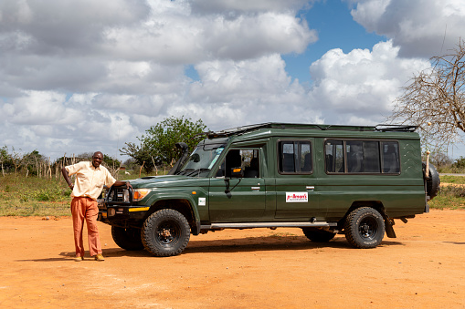 Tsavo Est, Kenya, Africa, August  19, 2023, African safari guide in front of his off-road vehicle
